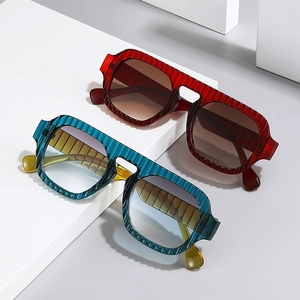 Retro pilot sunglasses with textured frames and gradient lenses shown on geometric blocks