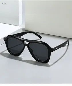 Close-up of vintage pilot sunglasses with polished black frames and silver wing detail