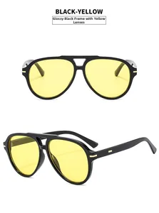 Detail view of black aviator sunglasses with yellow lenses and golden rivet accents