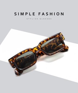 Close-up of stylish tortoiseshell square sunglasses with dark green lenses and rivets