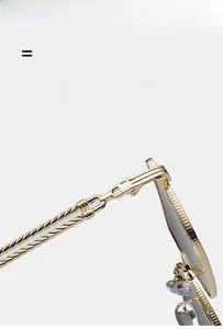 Detail of golden metal sunglasses showing dual-strand braided temples and textured frames