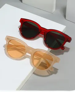 Detail of round sunglasses in translucent burgundy and nude pink resin frames