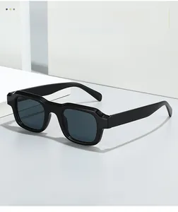 Close-up of black square sunglasses with thick frames and textured temple detail
