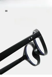 Detail of black oval glasses frame showing silver rivets and flexible texture material