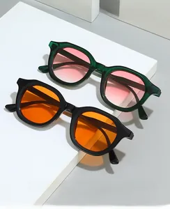Detail of retro oval sunglasses with thick frames in green and black with tinted lenses