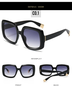 Detail view of square black sunglasses with gradient purple lenses and gold metal accents