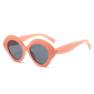 Modern oval sunglasses for women with a coral pink frame and dark grey lenses on white background