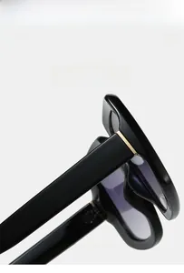 Detail of square sunglasses featuring black acetate frame and super elastic gold metal hinges