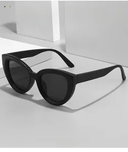 Detailed close-up of glossy black cat-eye sunglasses on a minimalist stone pedestal