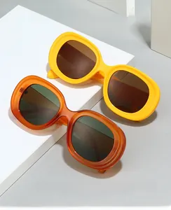 Detail of vintage thick-frame oval sunglasses in bright yellow and amber gradient finishes