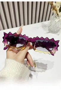 Detail of scalloped zigzag frame sunglasses with purple gradient finish and grey lenses