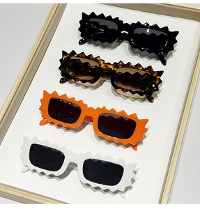 Detail of trendy thick-framed sunglasses with unique scalloped edges in four colors