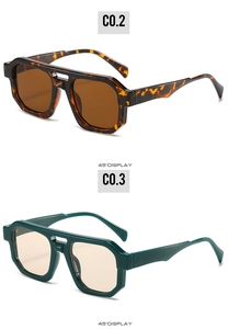 Detail view of large geometric sunglasses with tortoiseshell and dark green frames