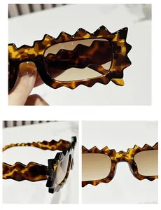 Detail view of scalloped edge tortoise shell sunglasses with brown gradient lenses
