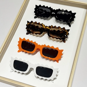 Irregular scalloped edge sunglasses for women in black, tortoise, orange, and white frames