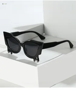Detail of cat eye sunglasses with crystal water drop accents on black chunky frames
