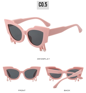Detail view of pink cat-eye sunglasses with rhinestone teardrop accents and grey lenses