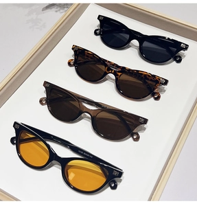 Close-up of retro oval sunglasses showing four colors and silver B-shaped metal temple detail