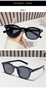 Detail of black oval sunglasses featuring silver double rivets and dark grey lenses