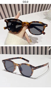 Detail view of oval leopard print sunglasses with metal studs and dark lenses