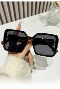 Detail of tortoise shell square sunglasses with gold metal accents on the frame temples