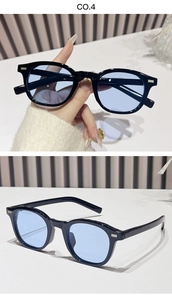 Detail of oval black frame sunglasses with light blue lenses and silver rivet accents