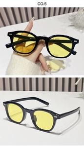 Close-up of retro black frame sunglasses with yellow lenses and metallic rivets