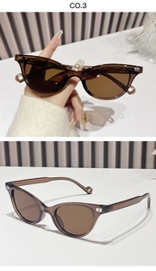 Detailed close-up of brown cat-eye sunglasses with silver B-shaped metal logo on the frame