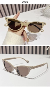 Detail of tea-colored cat-eye sunglasses with silver B-shaped metal accents and dark lenses
