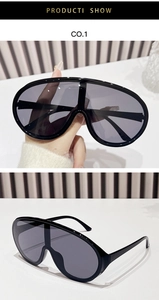 Dettaglio di occhiali da sole a maschera oversize con montatura nera e lenti grigie Y2K