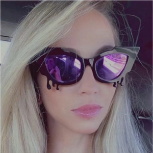Fashionable cat eye sunglasses with purple reflective lenses and black drip frame effect