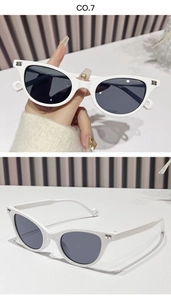 Macro shot of white cat-eye sunglasses featuring metallic letter B detail on the frame