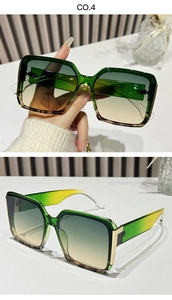 Detail of square oversized sunglasses with green yellow gradient lenses and gold accents