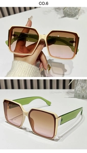 Detail view of square vintage sunglasses with cream and brown frames and green temples