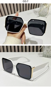 Detail of retro square sunglasses featuring black and white frame with gold metal hinge