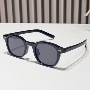 Retro black oval sunglasses with silver metal accents on a minimalist background