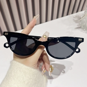 Chic black cat eye sunglasses with metallic B logo detail and dark UV lenses
