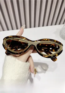 Detailed macro view of tortoiseshell oval sunglasses with gold metal decorative inlay