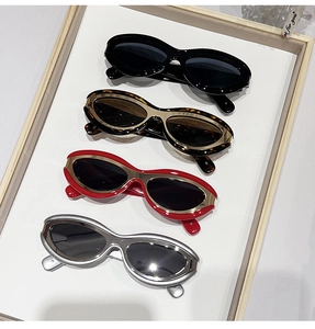 Detail view of oval sunglasses in black, tortoiseshell, red and silver metal frames