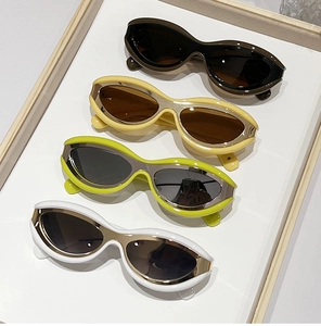 Detail view of retro oval sunglasses in brown yellow green and white on a tray