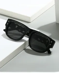 Detail of square black oversized sunglasses featuring hollowed chain temples and metal rivets