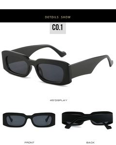 Detail view of bold black rectangular sunglasses with thick frames and grey lenses