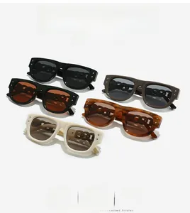 Detail view of square sunglasses with chunky chain temples and metal rivet accents