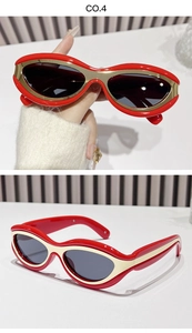 Detailed view of red cat-eye sunglasses with golden metal trim and dark lenses