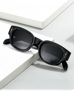 Détail de lunettes avec charnière métallique en épée dorée sur monture noire polie