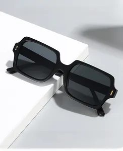 Detail of square vintage sunglasses with gold metal hinges on white geometric stand