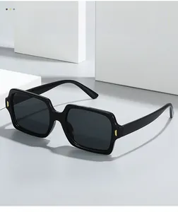 Detail of square vintage sunglasses with black glossy frame and gold metal accents