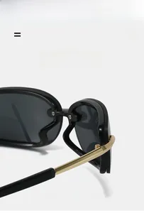 Detail of square Y2K sunglasses showing golden metal hinges and premium texture