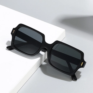 Retro black square sunglasses with thick frames and golden metal accents at the corners