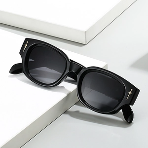 Lunettes de soleil carrées noires avec détails d'épée dorée sur socle géométrique